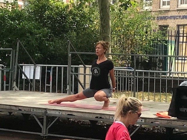 Démonstration d'une posture de yoga pendant un cours en extérieur à Dunkerque